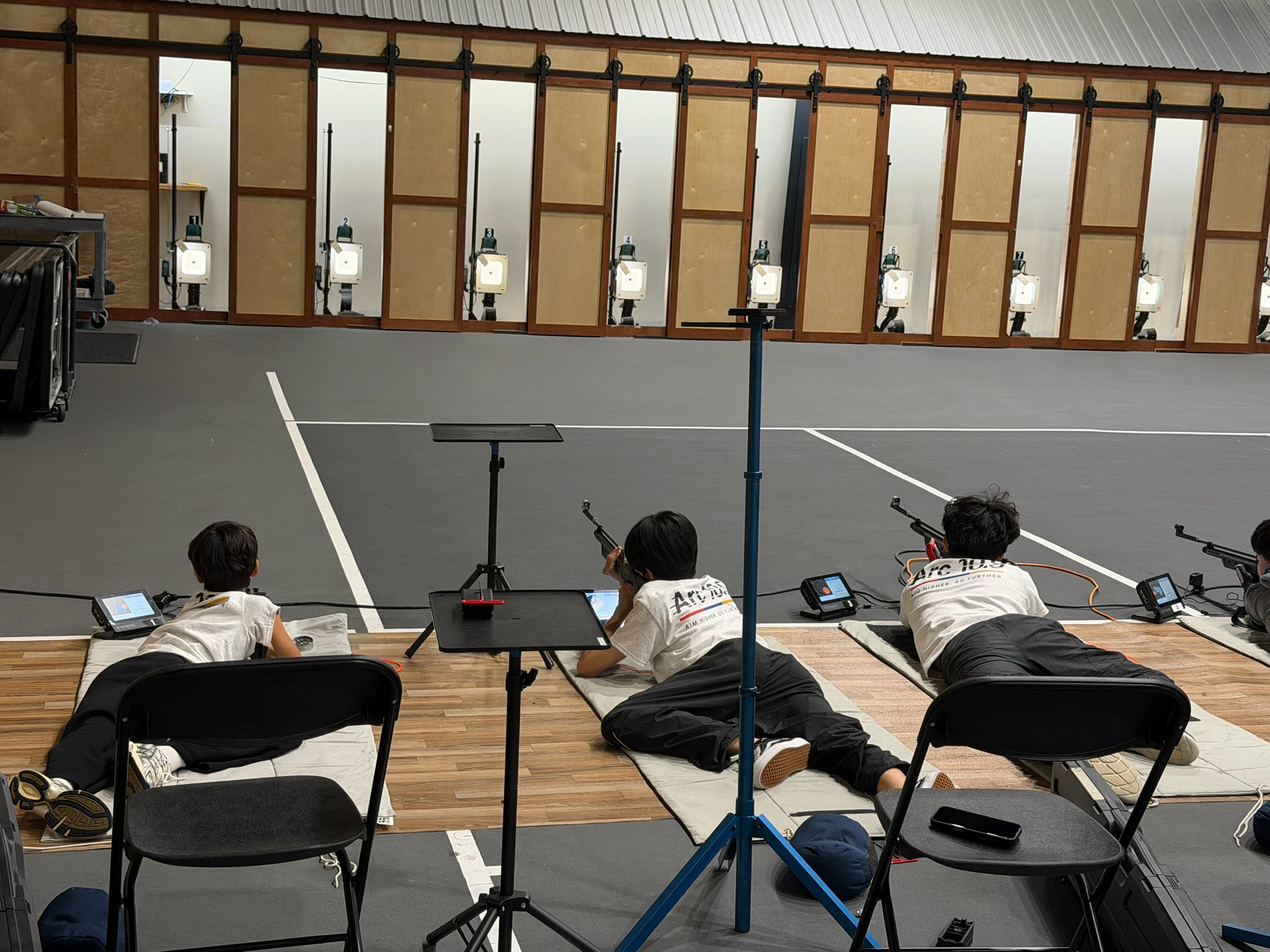 Sky Arc athletes competing from the prone position across the academy firing line